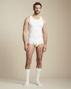 man wearing white cotton tank top, brief, and socks